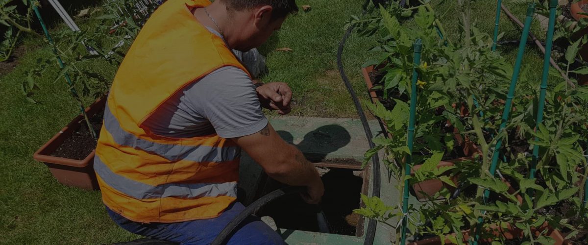 Operator la căminul unei fose dintr-o grădină